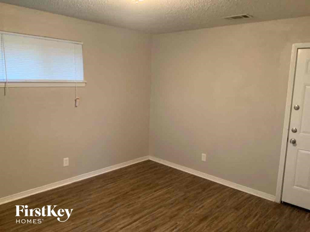 an empty room with wooden floors and a window