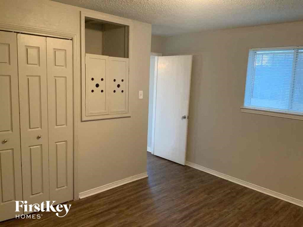 an empty living room with a door and a closet