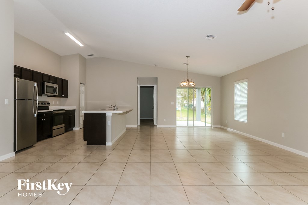 an empty kitchen and living room with a door to the backyard