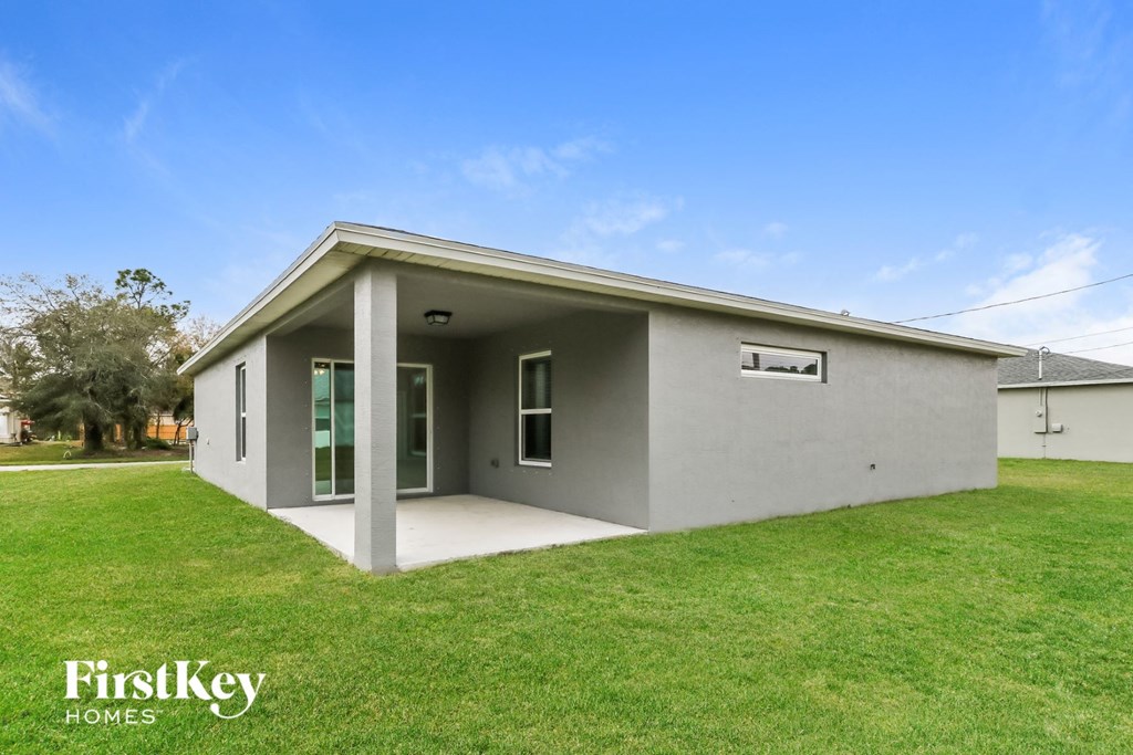 a small gray house with a grassy yard and a lawn