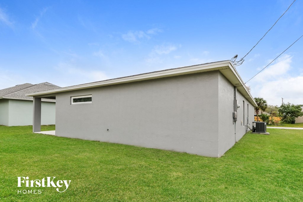 the front of a white house with a grassy yard