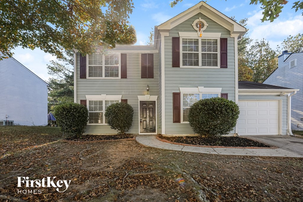 A two-story house with a garage is for sale.