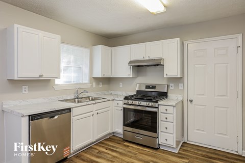 A kitchen with white cabinets and a stainless steel refrigerator.