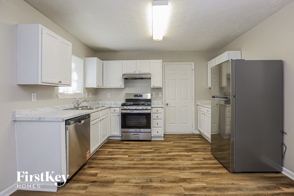 A kitchen with wooden floors and white appliances.