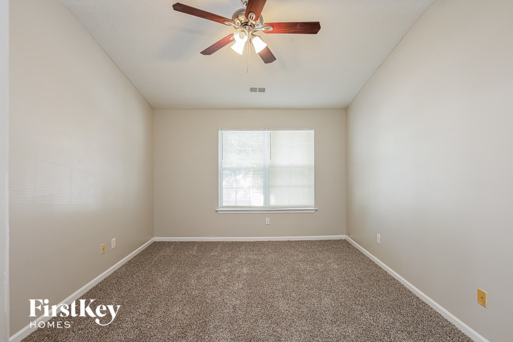 A room with a ceiling fan and a window.