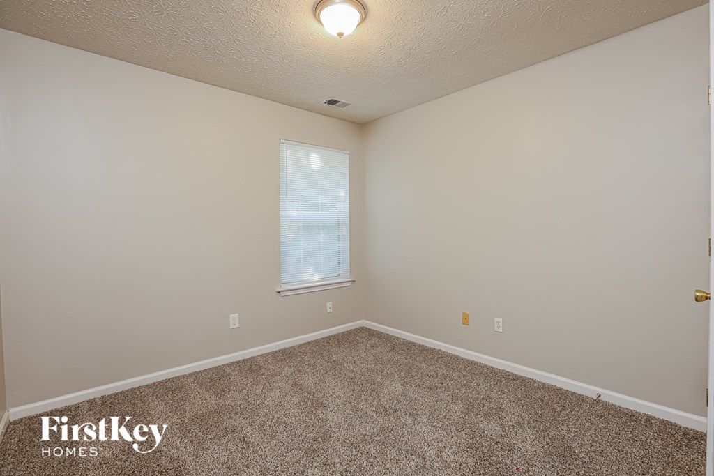 A room with a carpeted floor and a window.