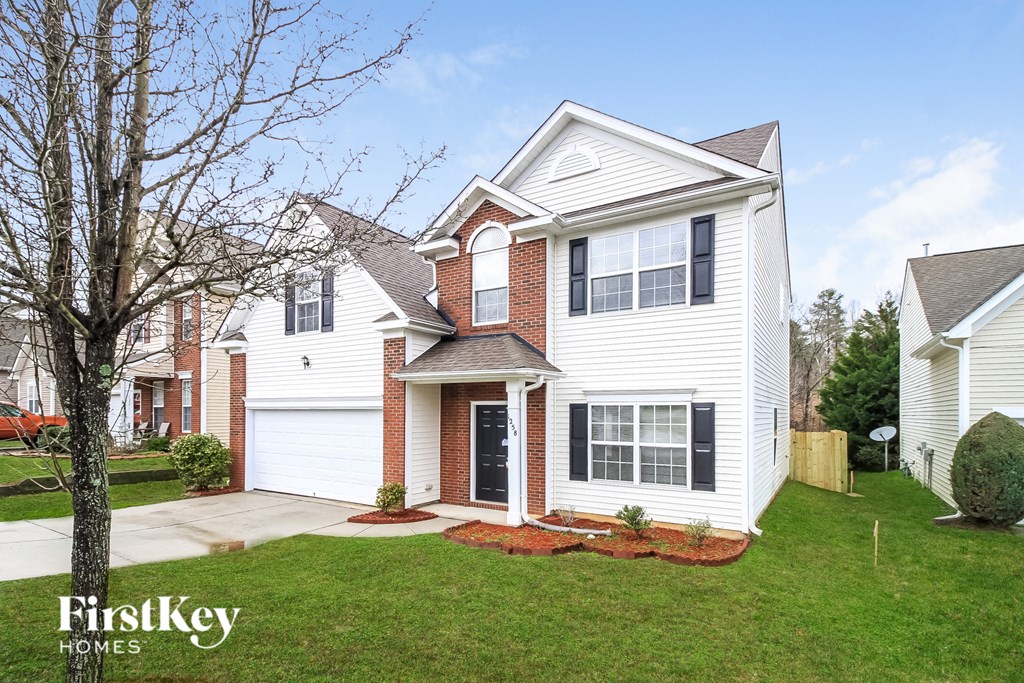 a white house with black shutters and a lawn