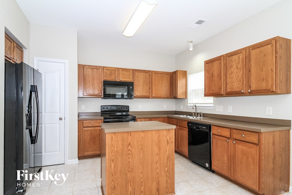 a kitchen with wooden cabinets and black appliances and a counter top