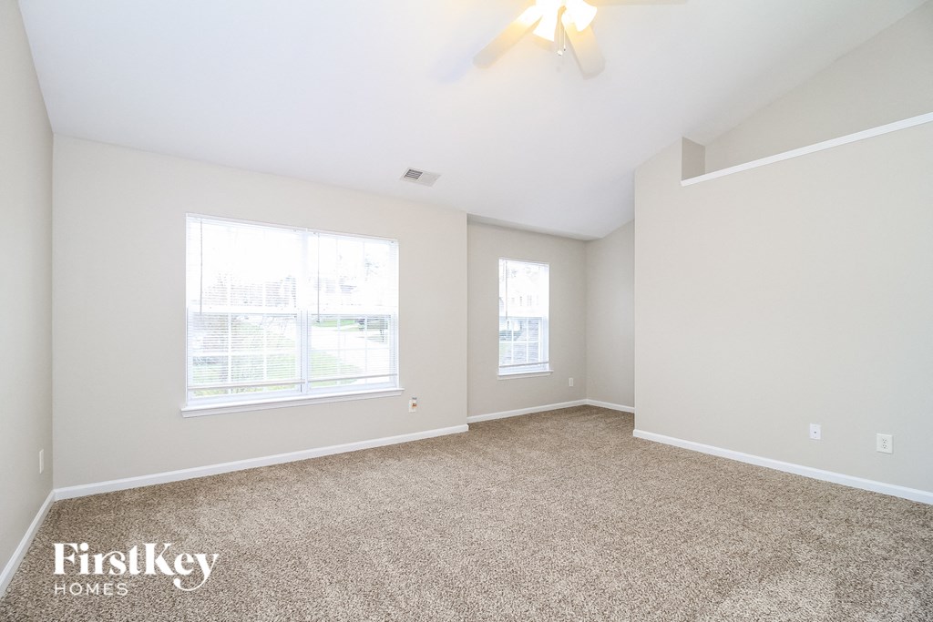 a spacious living room with carpet and a large window