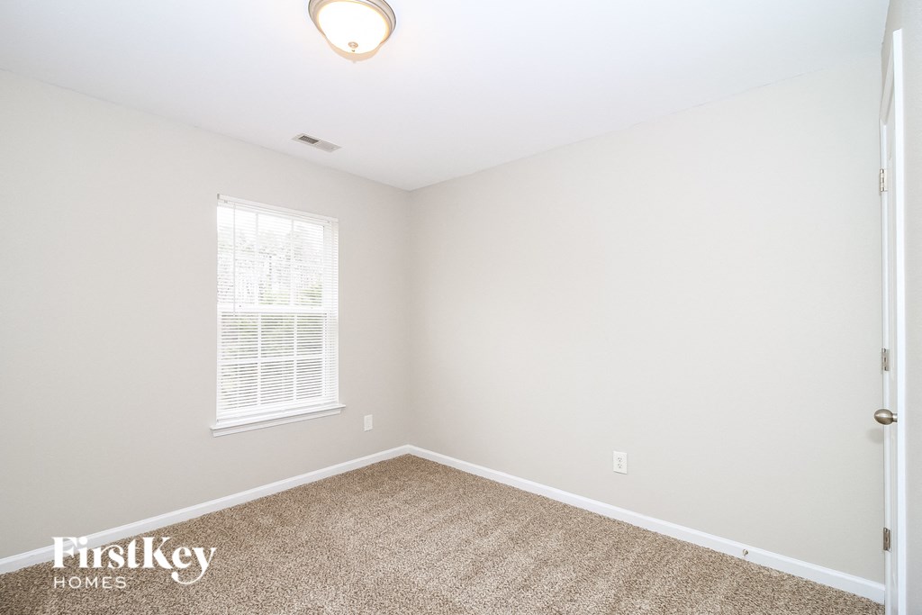 a bedroom with a carpeted floor and a window
