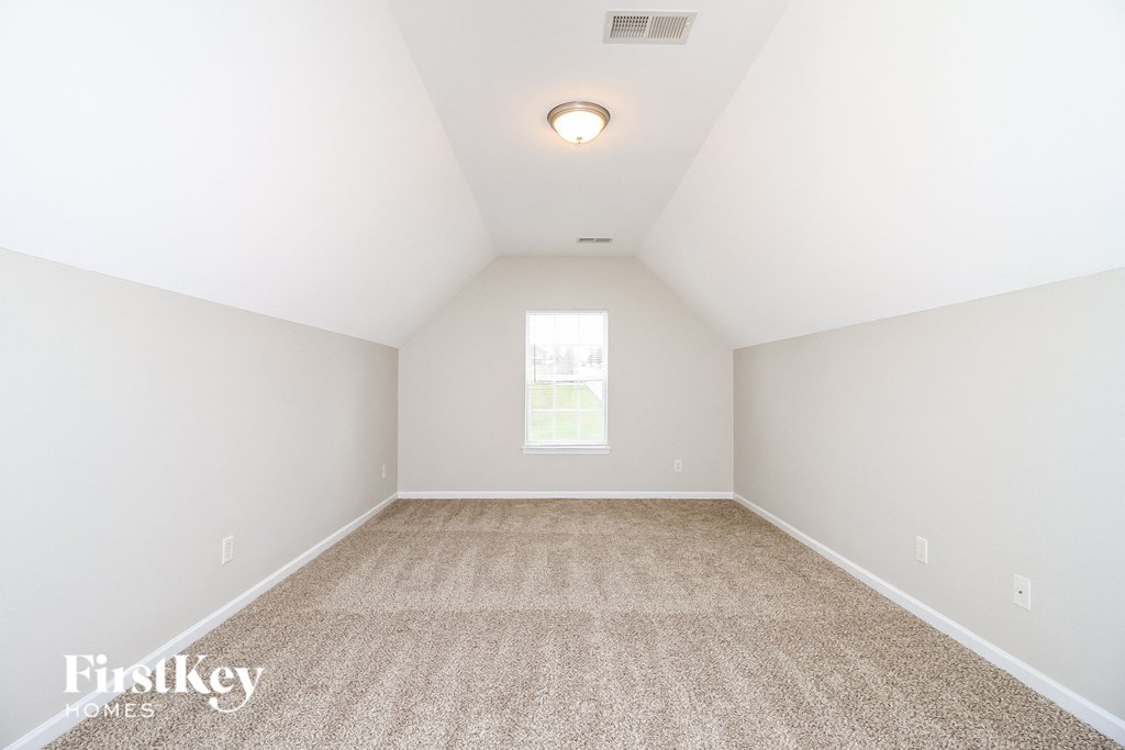 a empty room with carpet and a window