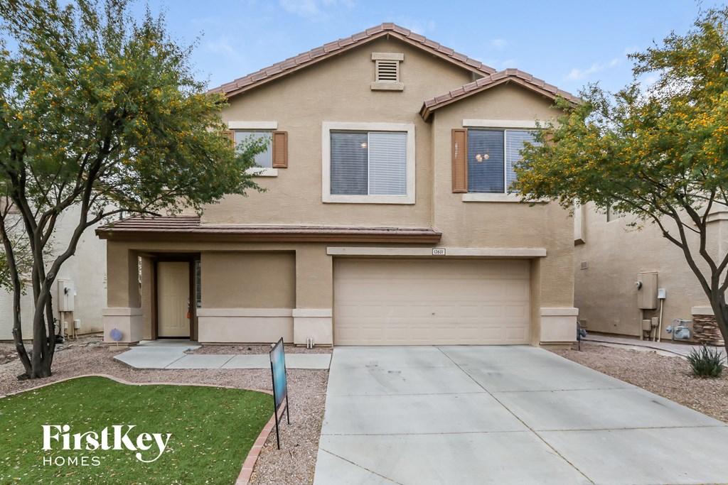 a beige house with a driveway in front of it