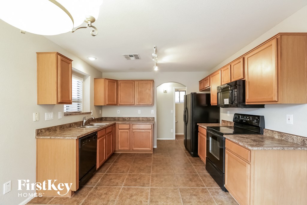 a kitchen with wooden cabinets and black appliances