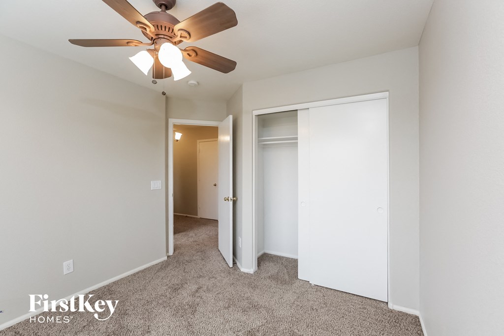 a bedroom with a ceiling fan and a closet