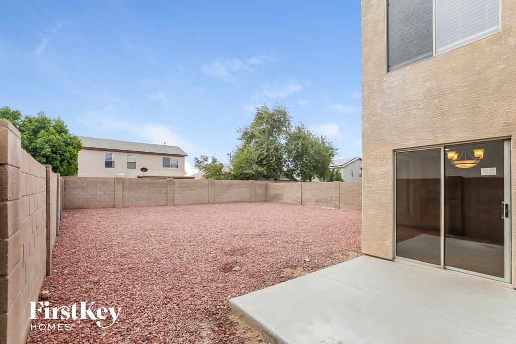 a backyard with a brick wall and a patio with a glass door