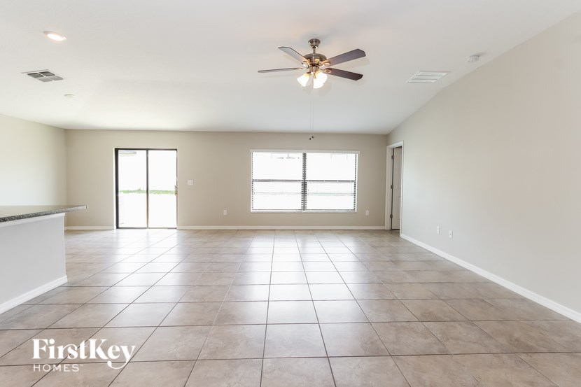 A spacious room with a ceiling fan and tile flooring.
