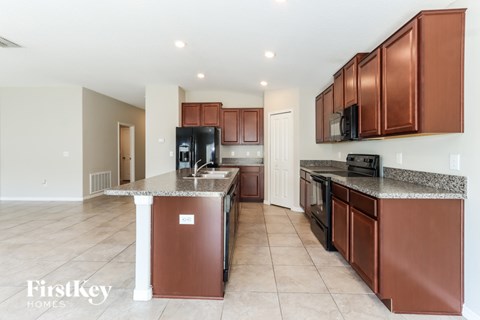 A kitchen with brown cabinets and a granite countertop.