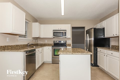 A kitchen with granite countertops and stainless steel appliances.