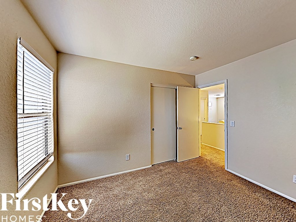 a bedroom with a large window and a door to a hallway