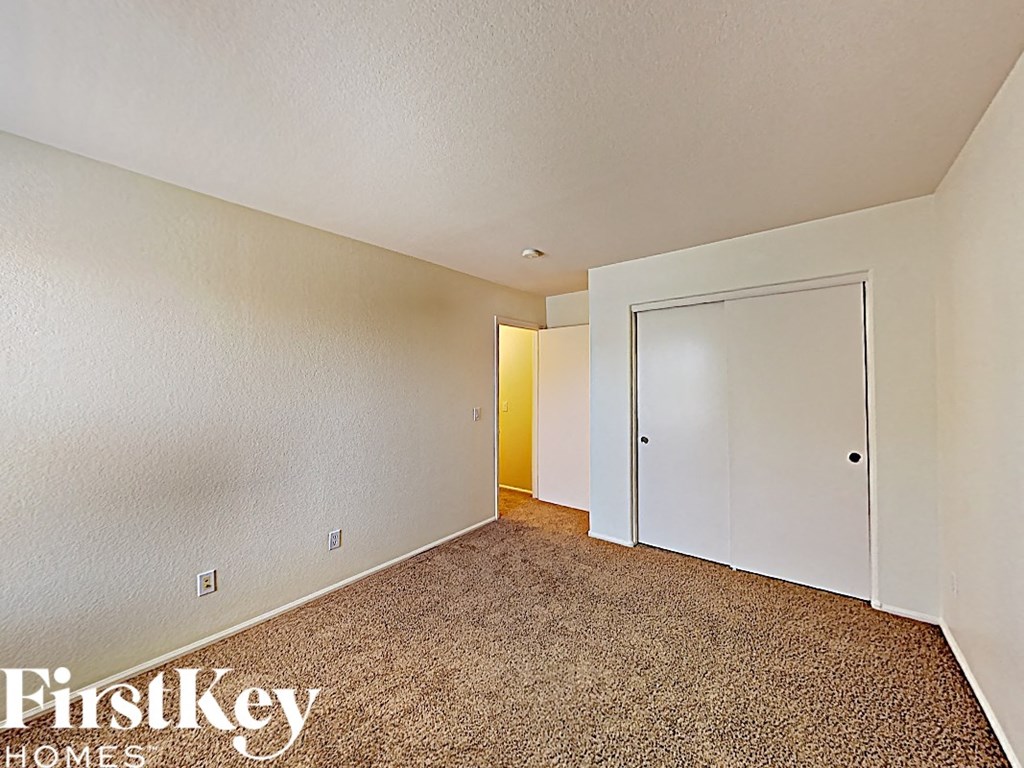 the living room of an apartment with a door to a closet
