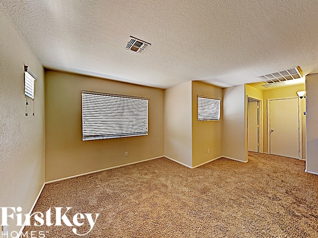 an empty living room with a window and a door