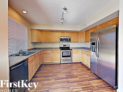 a kitchen with wooden floors and stainless steel appliances