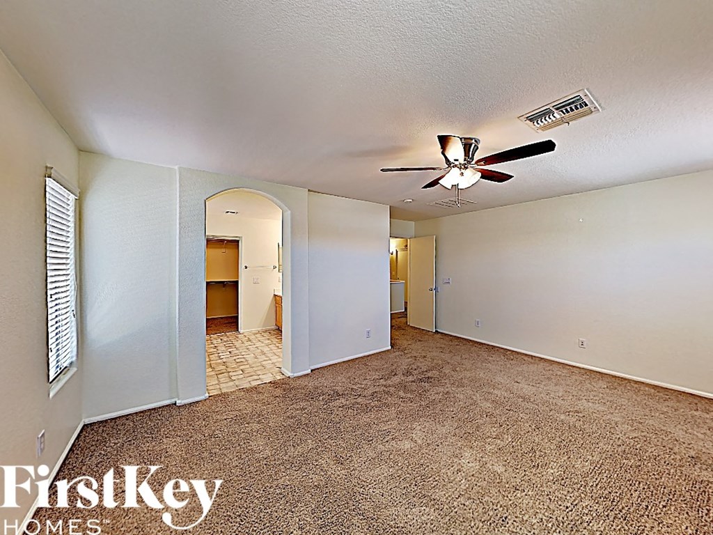 the living room of an empty house with a ceiling fan