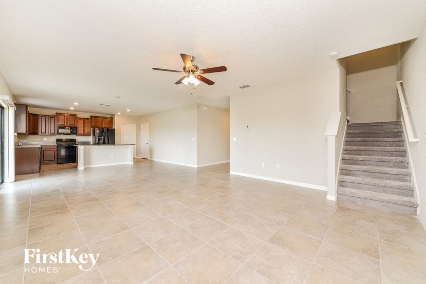 A spacious living room with a staircase leading to the upper floor.