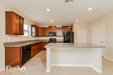 A kitchen with brown cabinets and a granite countertop.