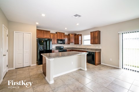 A kitchen with a white island in the middle of the room.