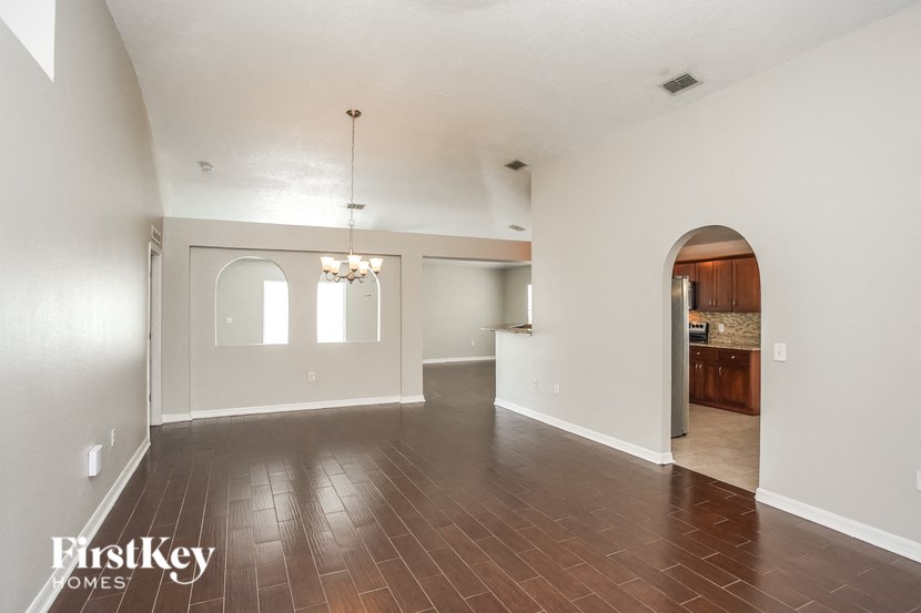the living room and dining room with the kitchen in the background