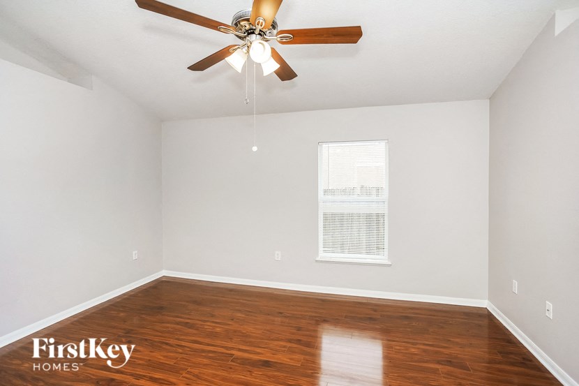 a living room with hardwood floors and a ceiling fan