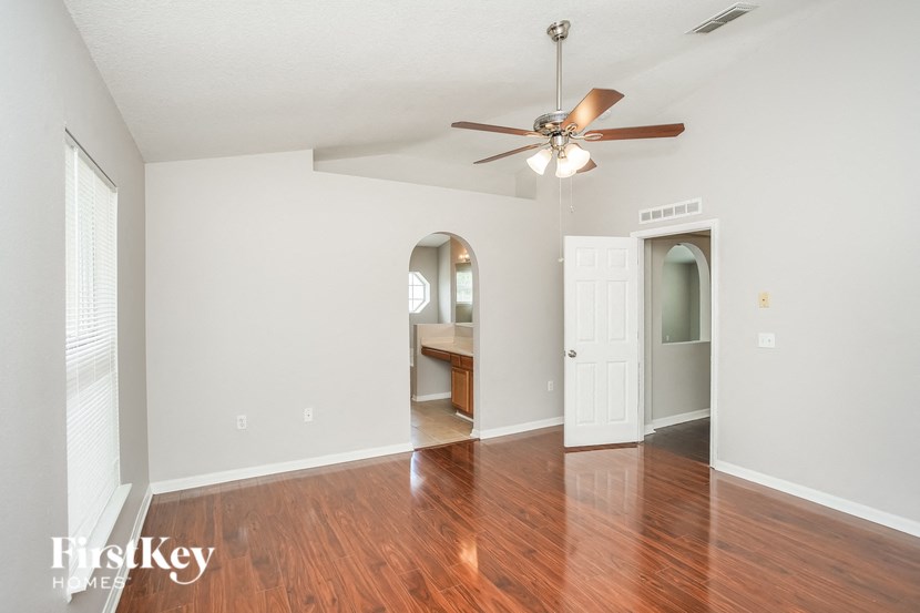 a living room with wood floors and a ceiling fan