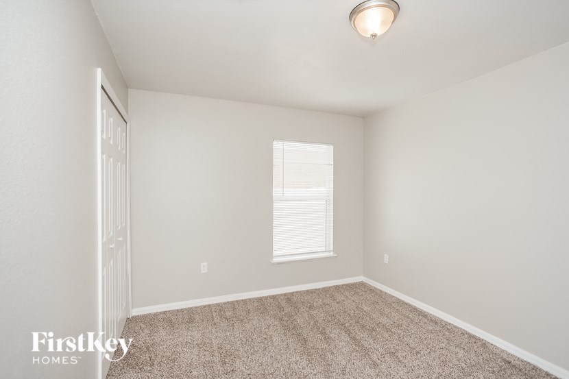 an empty room with carpet and a window