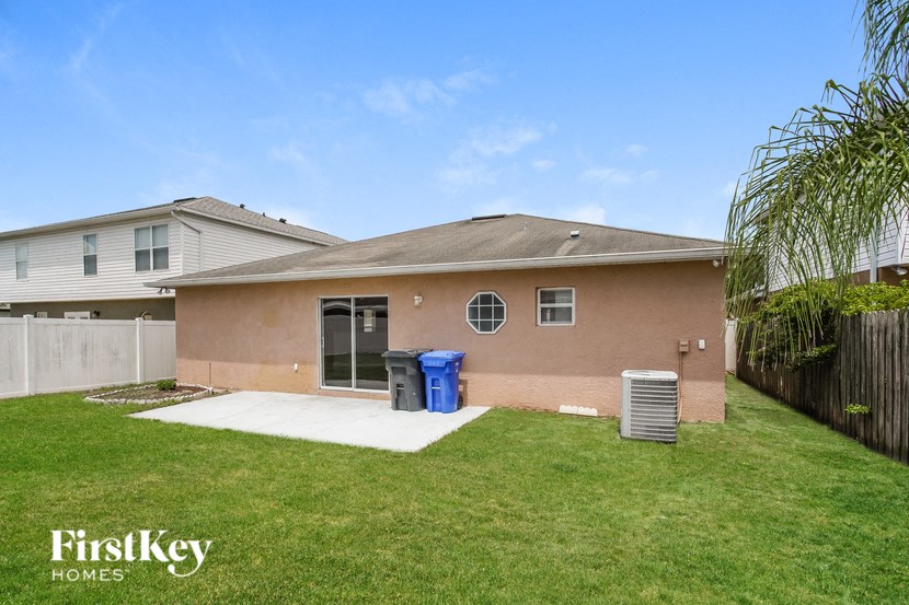 a home with a yard and a trash can in front of it