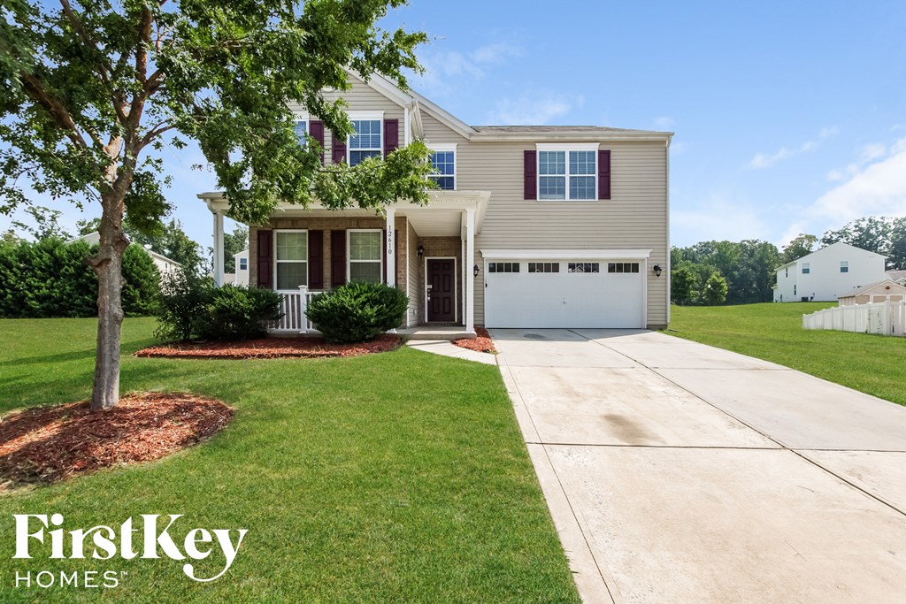 a beige house with a white garage door and a lawn