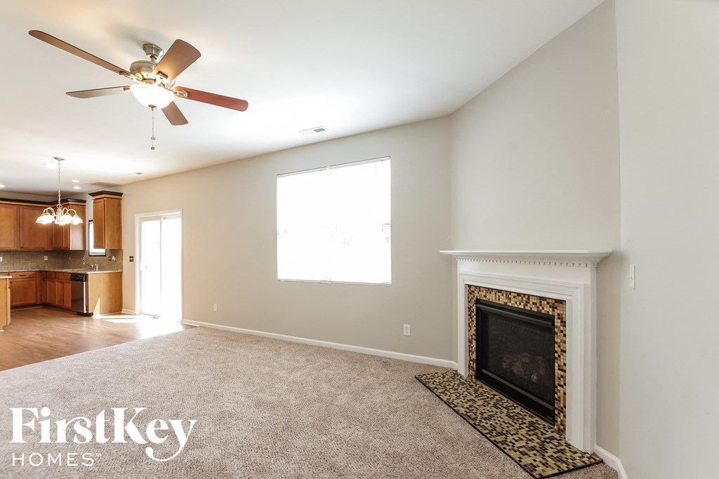 a living room with a fireplace and a ceiling fan