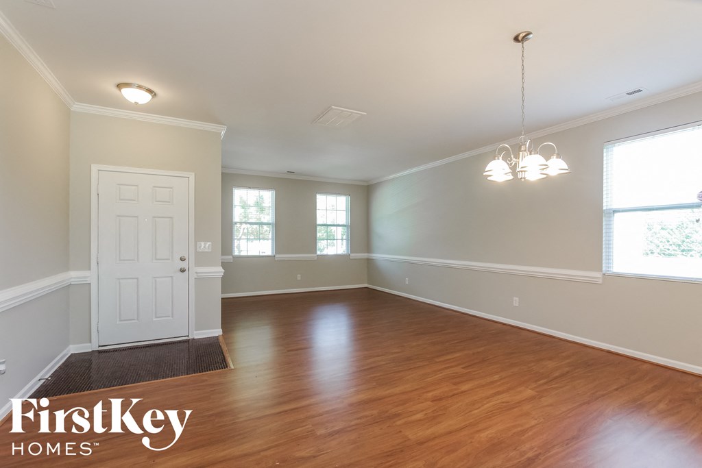 an empty living room with wood floors and a white door