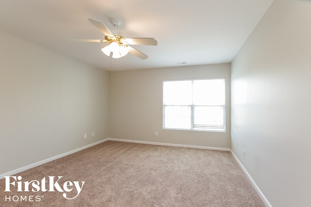 a bedroom with a ceiling fan and a window