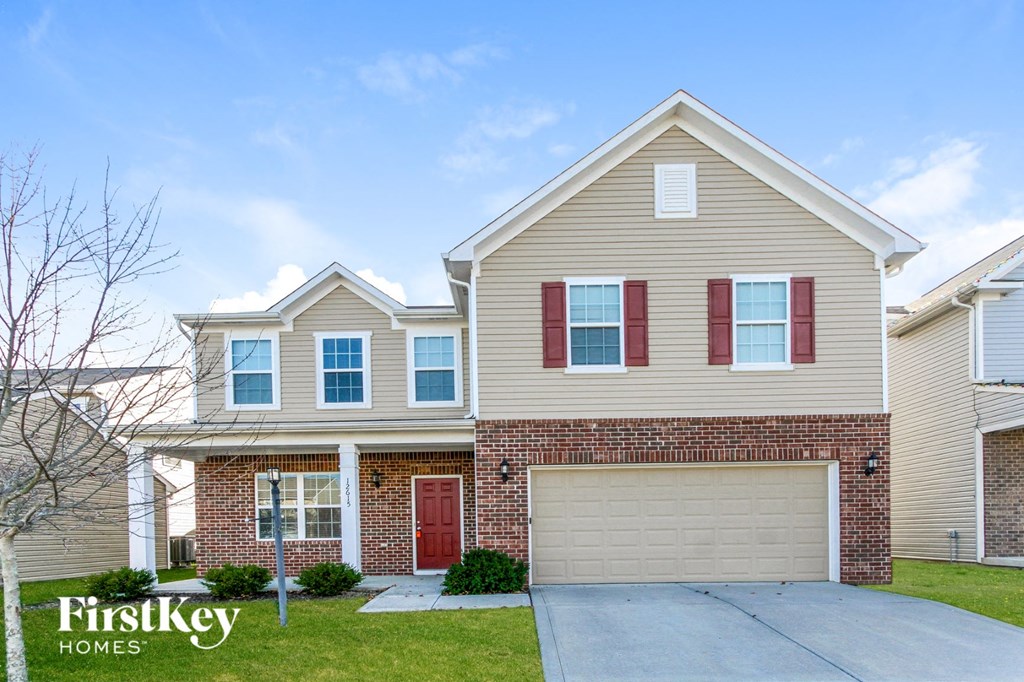 A house with a red door and a garage door.
