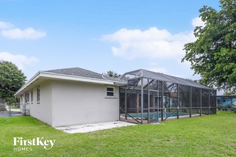A house with a pool and a glass enclosed area.