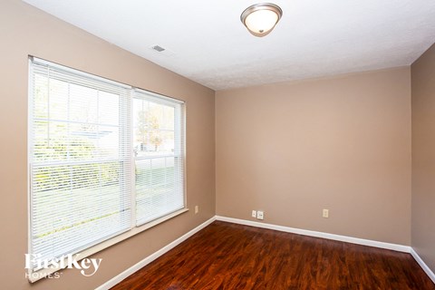 a living room with a large window and wooden floors