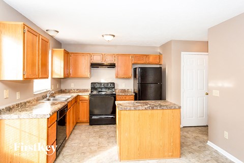 a kitchen with wooden cabinets and black appliances
