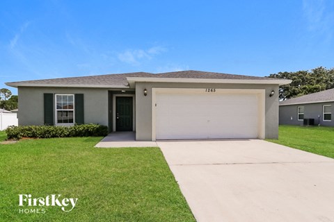 a beige house with a garage and a lawn