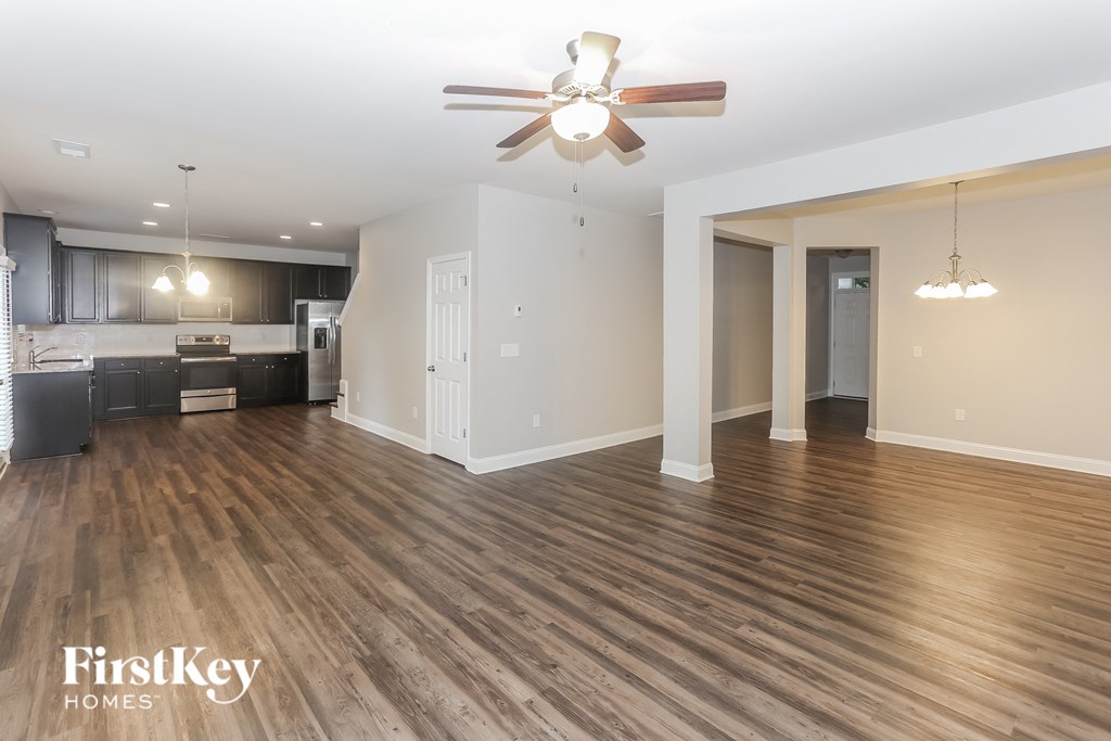 a living room and kitchen with wood flooring and a ceiling fan