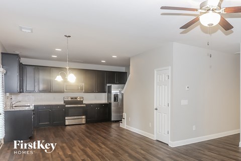 a kitchen with black cabinets and a ceiling fan