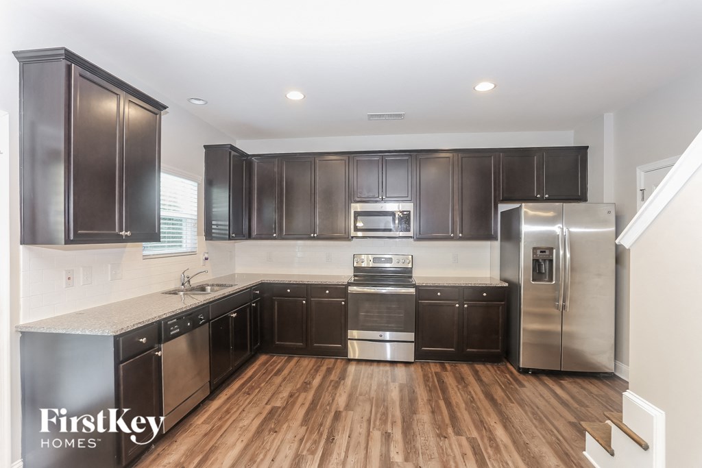 a kitchen with dark wood cabinets and stainless steel appliances