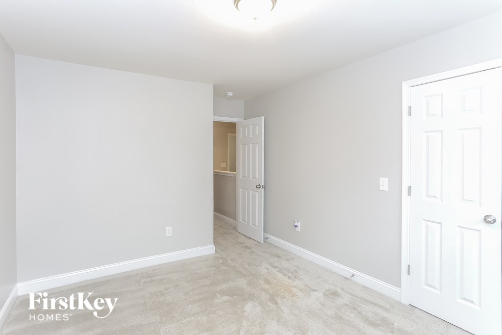 a living room with a white wall and a door to a closet
