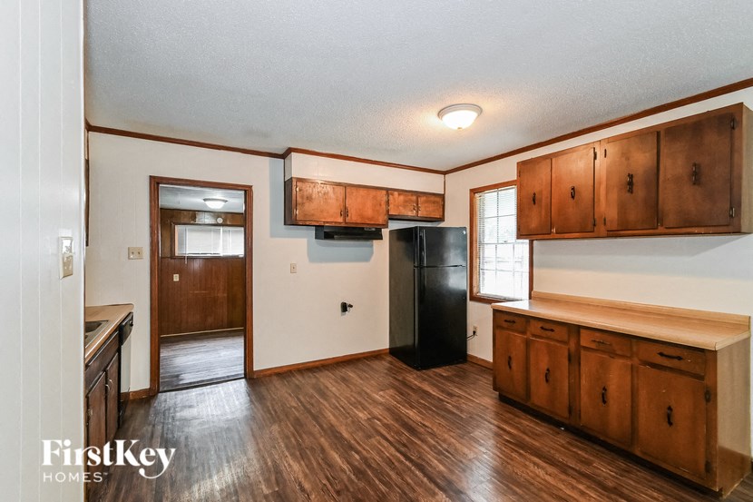 A kitchen with wooden cabinets and a black refrigerator.