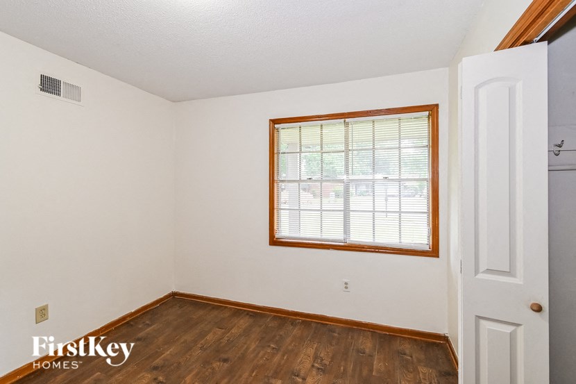 A room with a window and wooden floors.